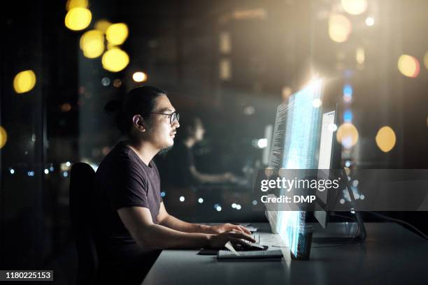 hij werkt aan een aantal gloednieuwe code - alone office night stockfoto's en -beelden