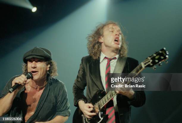 From left, vocalist Brian Johnson and guitarist Angus Young, playing a black Gibson SG guitar, perform live on stage with hard rock group AC/DC at...