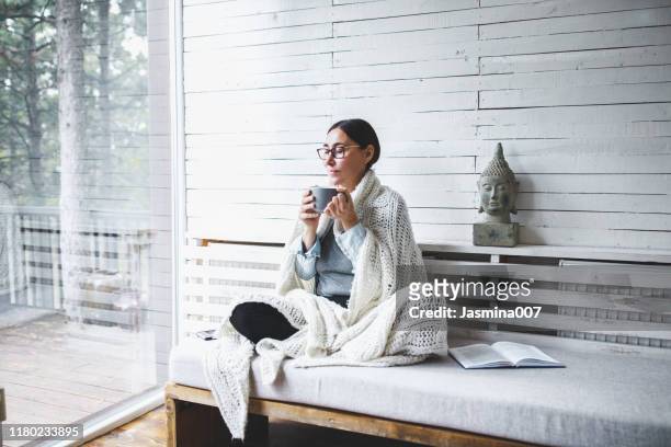 middle-aged woman siting comfortable and enjoys tea - chill out stock pictures, royalty-free photos & images