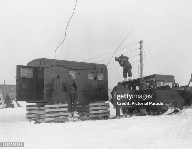 Men of the US Army Polar Research and Development Center setting up communications at the temporary camp used during the construction of Camp...