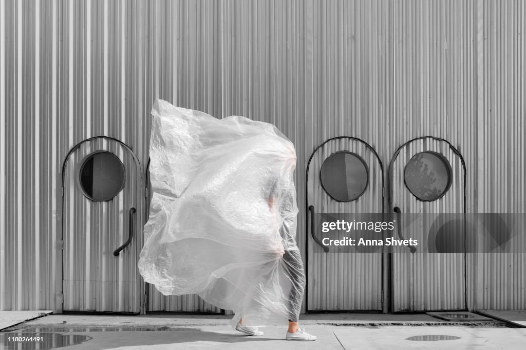 A man in a plastic on the background of a silver tin building