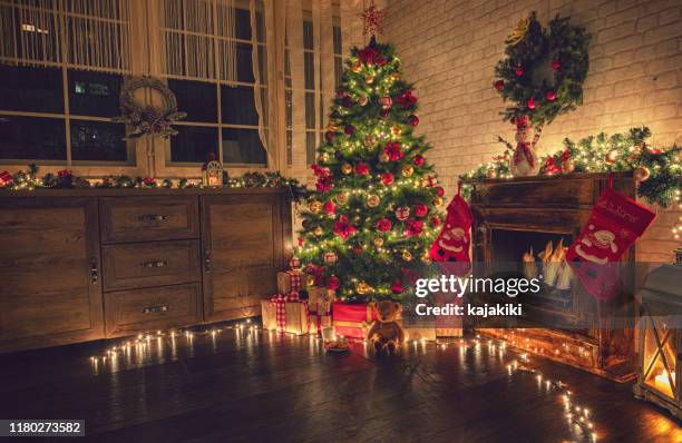 dekorierter weihnachtsbaum in der nähe von kamin zu hause - baum haus stock-fotos und bilder