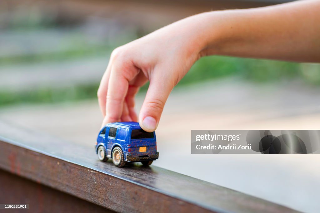 Children kid playing blue color car toy. Child hand playing with car