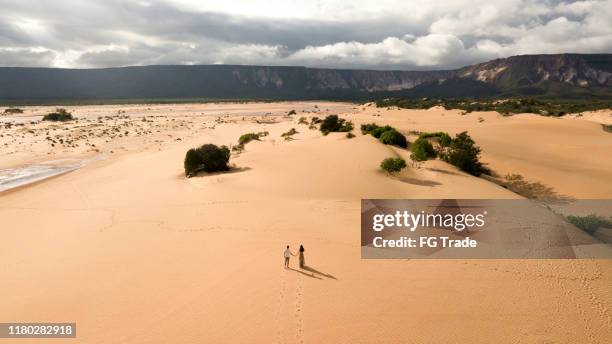 aerial view of couple walking in the sand dunes of jalapão, tocantins - tocantins stock pictures, royalty-free photos & images