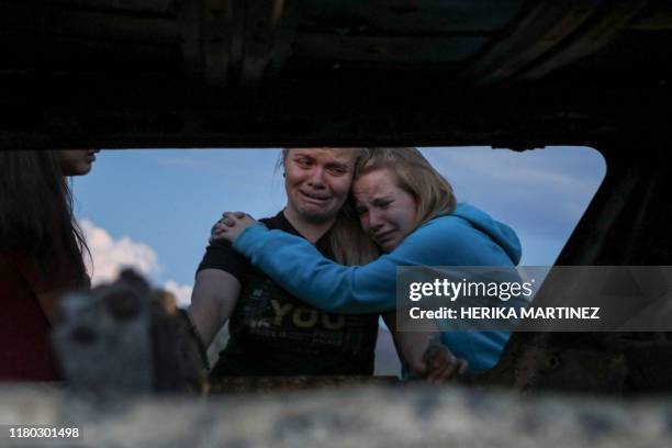 Members of the Lebaron family mourn while they watch the burned car where part of the nine murdered members of the family were killed and burned...