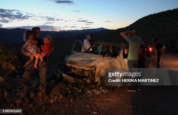 Members of the LeBaron family look at the burned car where part of the nine murdered members of the family were killed and burned during an ambush in...