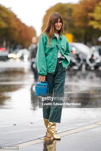 Gala Gonzalez wears a green denim jacket, a white top, green pants, golden boots, a blue Chanel bag, outside Chanel, during Paris Fashion Week -...