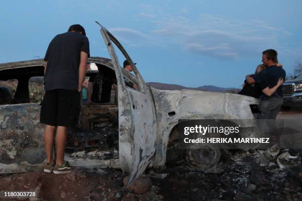 Members of the Lebaron family look at the burned car where part of the nine murdered members of the family were killed and burned during an ambush in...