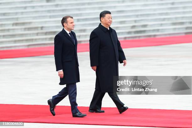 Chinese President Xi Jinping accompanies French President Emmanuel Macron to view an honour guard during a welcoming ceremony outside the Great Hall...