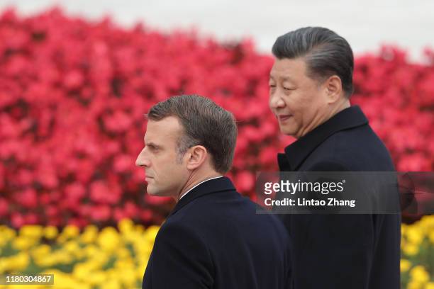 Chinese President Xi Jinping accompanies French President Emmanuel Macron to view an honour guard during a welcoming ceremony outside the Great Hall...
