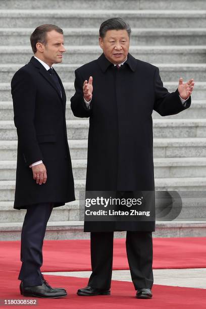 Chinese President Xi Jinping talk with French President Emmanuel Macron during a welcoming ceremony outside the Great Hall of the People on November...