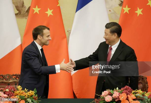 French President Emmanuel Macron shakes hands with China's President Xi Jinping after a joint news conference at the Great Hall of the People on...