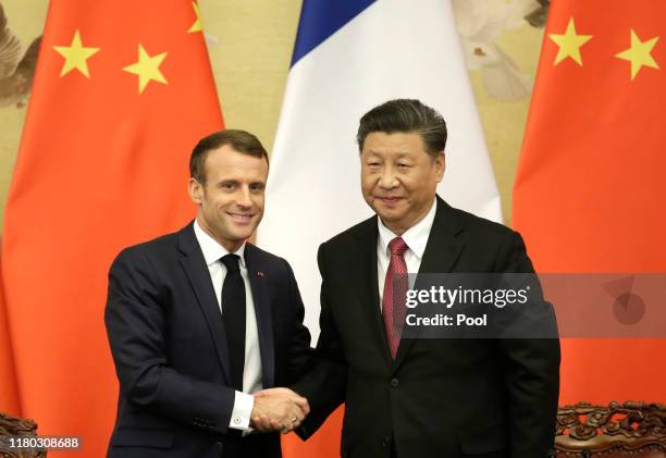 French President Emmanuel Macron shakes hands with China's President Xi Jinping after a joint news conference at the Great Hall of the People on...