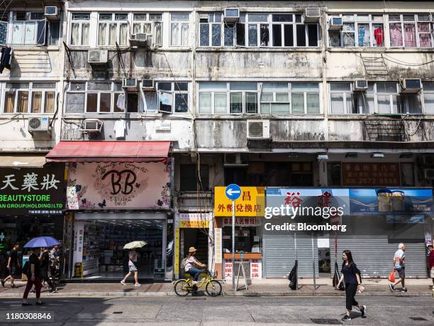 Pedestrians walk past stores in the Sheung Shui district of Hong Kong, China, on Thursday, Sept. 12, 2019. Hong Kong's waning allure for ambitious...