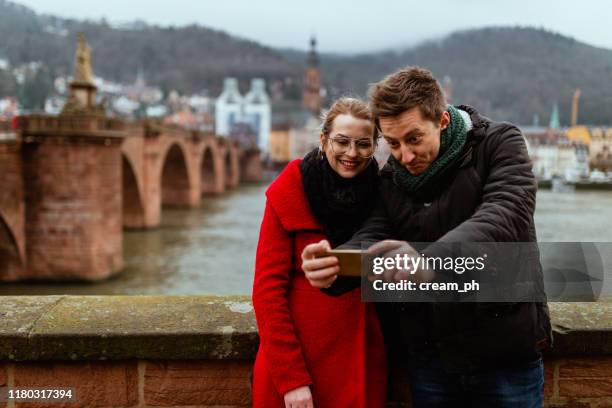 vrienden met behulp van slimme telefoon en fotograferen op een winterdag - aachen 2017 prize of north rhine westphalia stockfoto's en -beelden