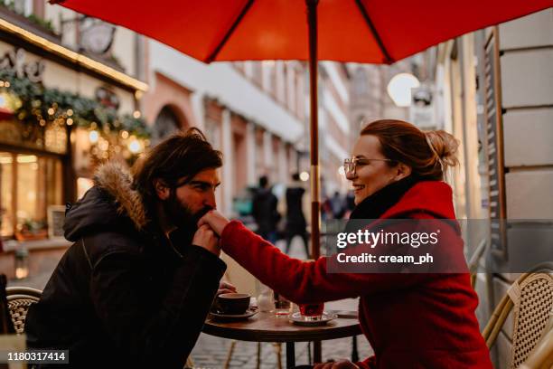 freund und freundin sitzen an einem wintertag im straßencafé - heidelberg stock-fotos und bilder