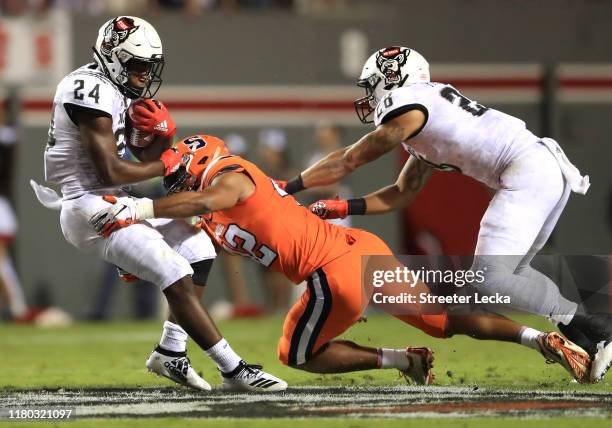 Zonovan Knight of the North Carolina State Wolfpack is hit by Tyrell Richards of the Syracuse Orange during their game at Carter Finley Stadium on...