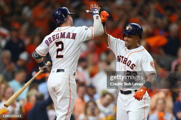 Michael Brantley of the Houston Astros is congratulated by his teammate Alex Bregman after hitting a solo home run against the Tampa Bay Rays during...