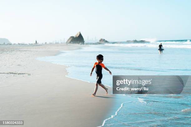 an asian boy play at currumbin beach, gold coast, australia - gold coast australia beach stock pictures, royalty-free photos & images