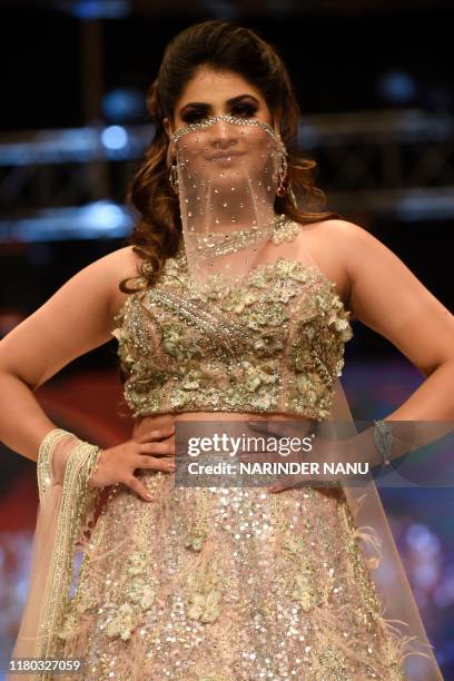 In this photo taken on November 5 a member of Federation of Indian Chambers of Commerce and Industry Ladies Organization walks on a ramp during the...