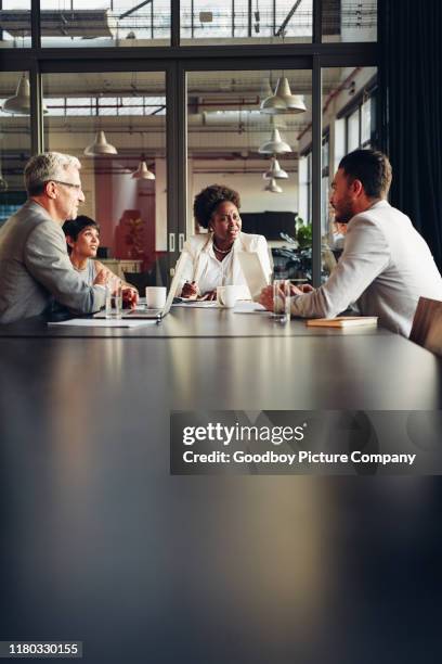 african american businesswoman listening to her team discussing work - mesa de reunião imagens e fotografias de stock