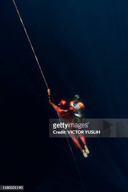 This photo taken on November 5, 2019 shows a safety diver watching on a competitor warmimg up prior to taking part in a freediving competition off...