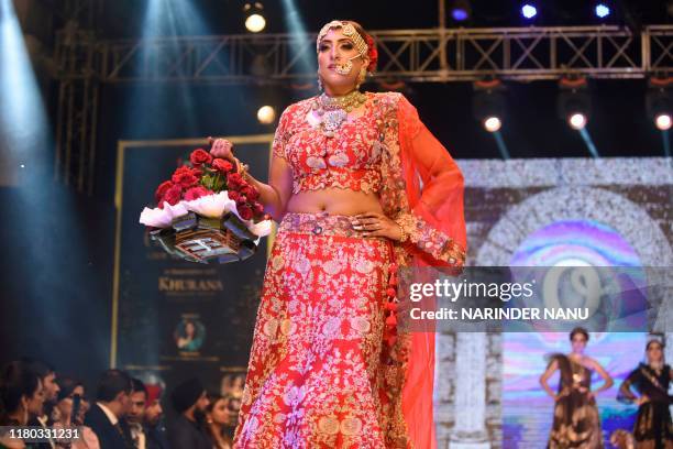 In this photo taken on November 5 members of Federation of Indian Chambers of Commerce and Industry Ladies Organization walk on a ramp during the...