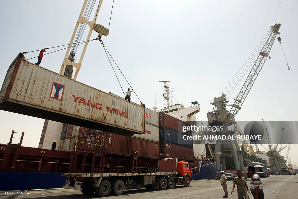 Iraqi workers prepare to unload a cargo