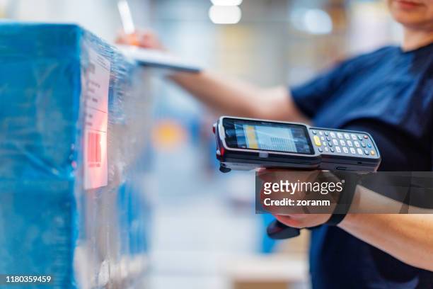 woman with barcode reader in warehouse - armazém de distribuição imagens e fotografias de stock