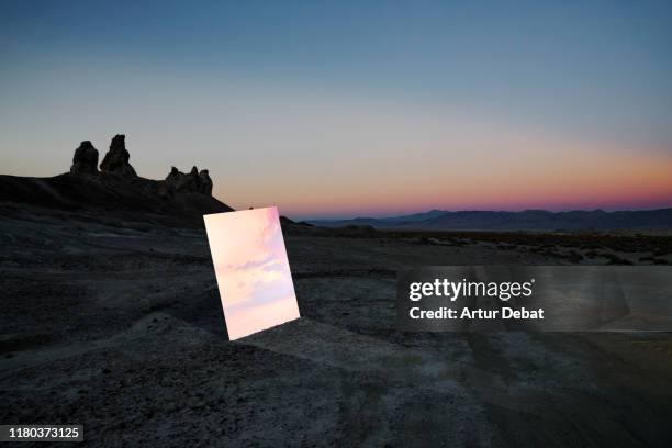 poetic picture of mirror reflecting sunset sky in the middle of desert in california. - installationskunst stock-fotos und bilder