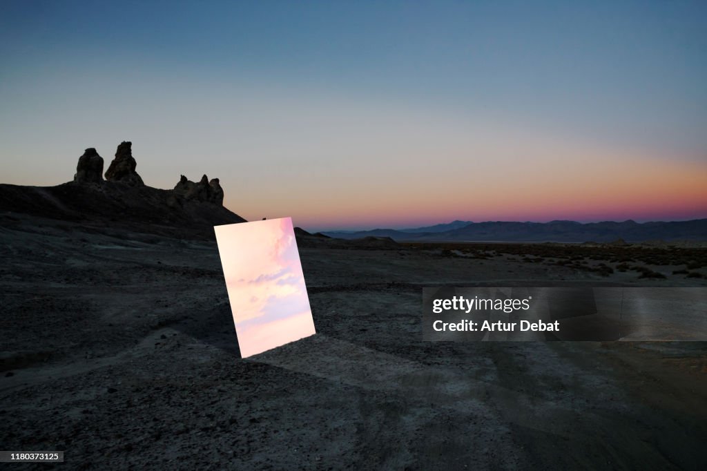 Poetic picture of mirror reflecting sunset sky in the middle of desert in California.