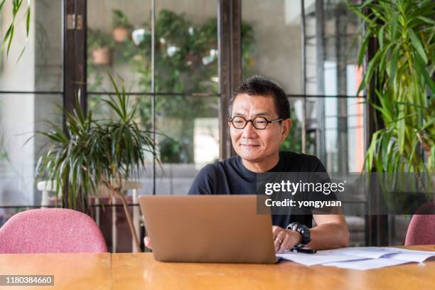 chinesischer architekt arbeitet an seinem laptop - elderly chinese man stock-fotos und bilder