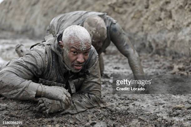 militärische schlammlauf crawling übung - militärisches trainingslager stock-fotos und bilder