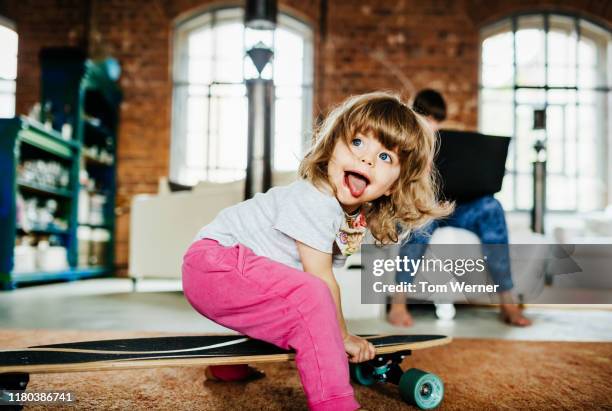 toddler playing on skateboard indoors - skateboarding moms photos et images de collection