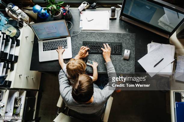 aerial view of mother working in office at home with daughter - telecommuting stock pictures, royalty-free photos & images