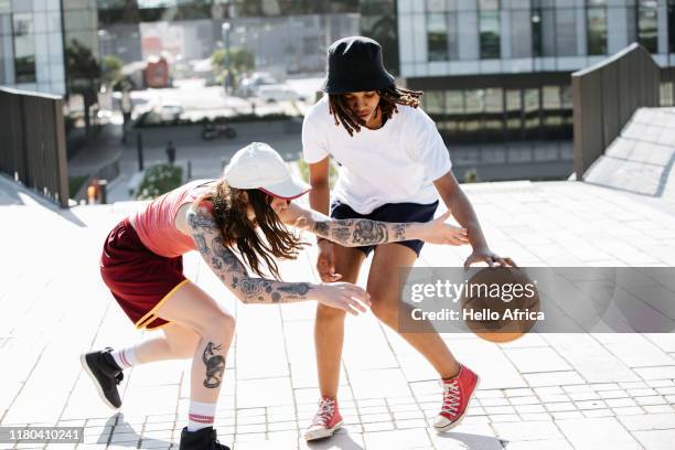 two young women dribbling a basketball - dribbling basketball stock pictures, royalty-free photos & images