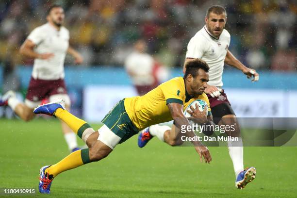 Will Genia of Australia scores his teams fourth try past Lasha Khmaladze of Georgia during the Rugby World Cup 2019 Group D game between Australia...
