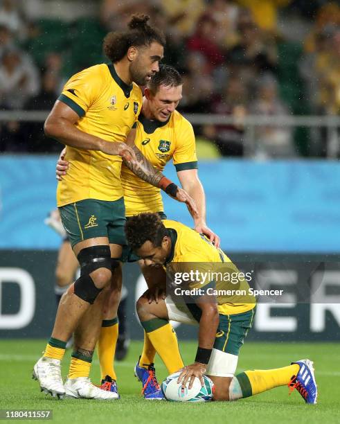 Will Genia of Australia celebrates with teammates Dane Haylett-Petty and Lukhan Salakaia-Loto of Australia after scoring his teams fourth try during...