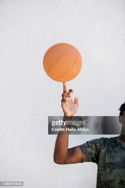 detail of basketball player spinning ball on finger - moeiteloos stockfoto's en -beelden
