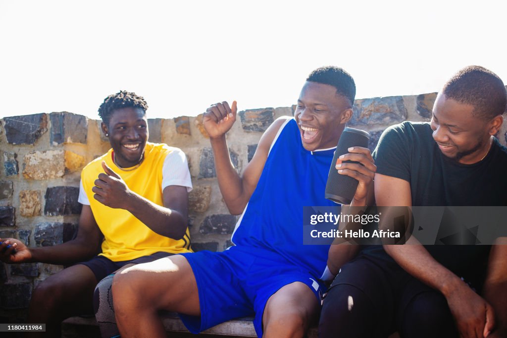 Happy friends grooving with portable speaker sound