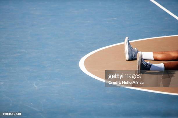 abstract of basketball player's feet on central part of basketball court - collapsing stock pictures, royalty-free photos & images