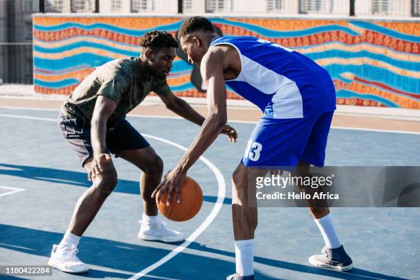 Two strong players facing off on basketball cort