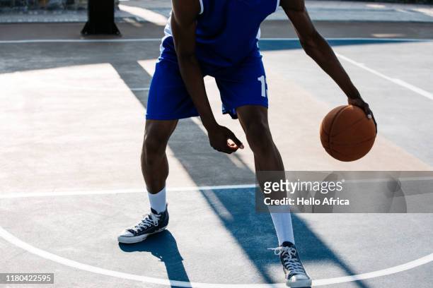 Cropped shot of basketball player dribbling on a hardcourt of
