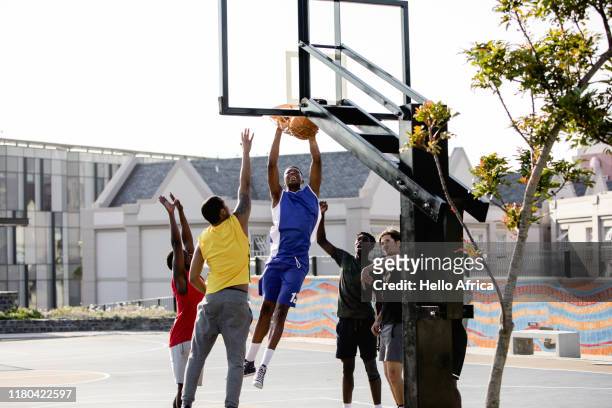 Basketball player makes a hoop and hangs on