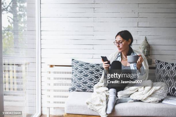 middle-aged woman siting comfortable and enjoys tea - cobertor imagens e fotografias de stock