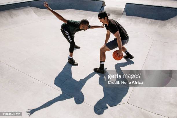 Basketball players dribbling and defending