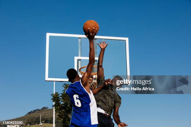 player wearing number 6 reaching to score whilst opponent defends - basketball competition stockfoto's en -beelden