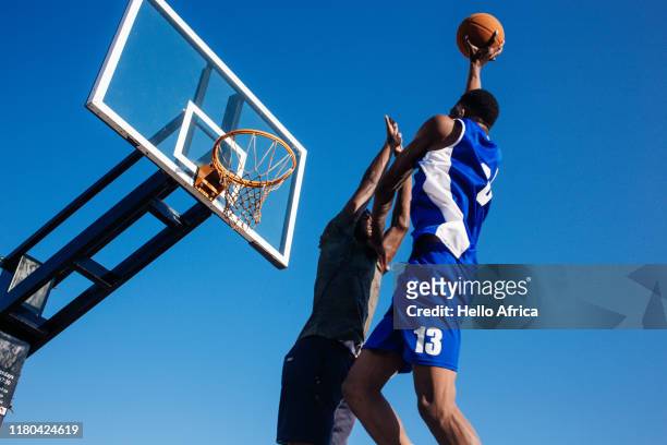 Low angle view of strong basketball players trying to score and defend