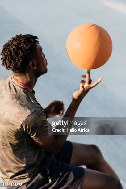 rear profile of cool basket player spinning a ball on his finger - pivot bildbanksfoton och bilder