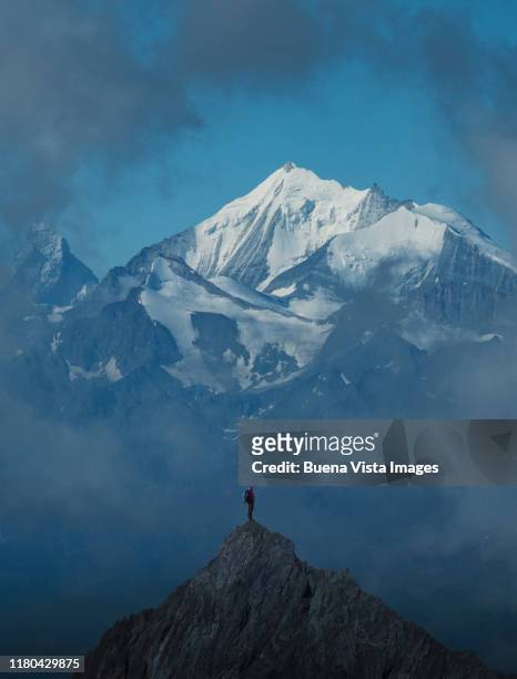 lone climber on a mountain peak - person standing far stockfoto's en -beelden